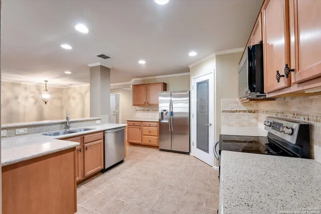 a large kitchen with stainless steel appliances kitchen island granite countertop a sink and cabinets