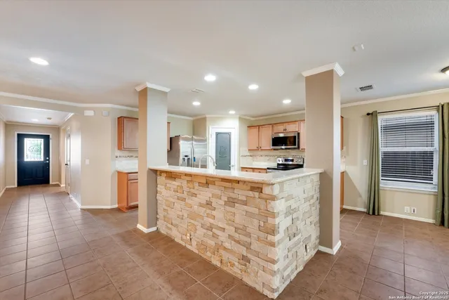 a large kitchen with stainless steel appliances kitchen island granite countertop a refrigerator and a stove top oven