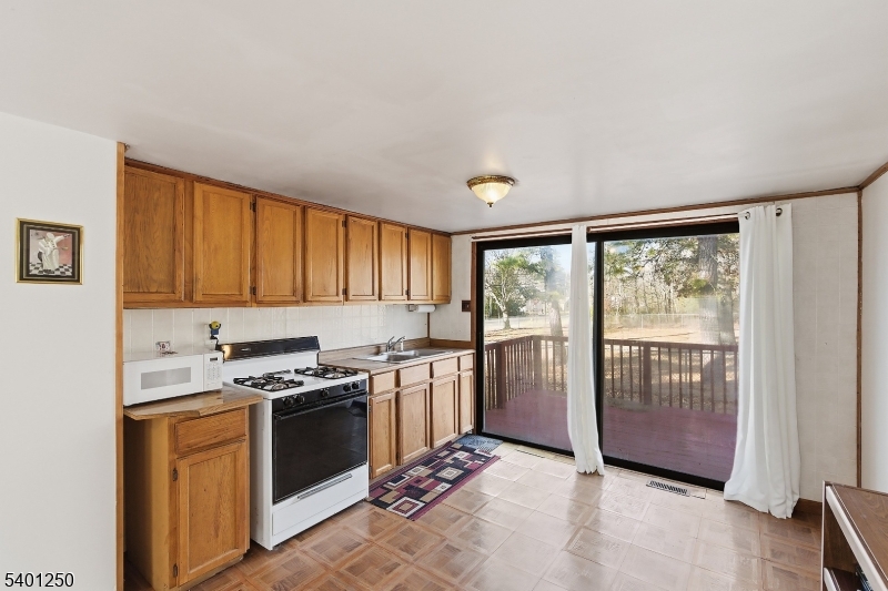 491 Lakehurst Road Browns Mills, NJ 08015 - Photo 8 of 17 a kitchen with stainless steel appliances granite countertop a stove a sink and a refrigerator with wooden floor