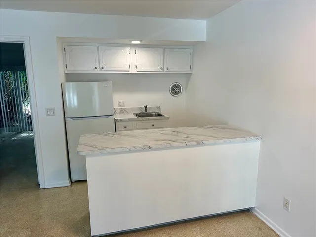 a kitchen with stainless steel appliances granite countertop a sink and a refrigerator