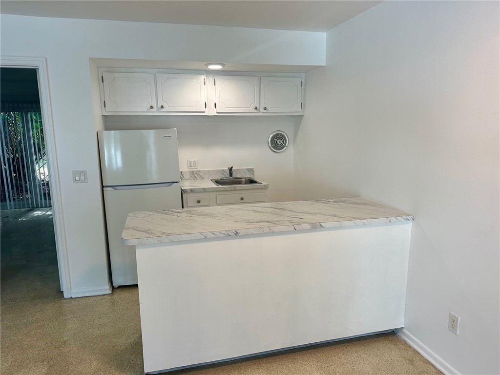 706 19th Street, Unit 3 Vero Beach, FL 32960 - Photo 4 of 9 a kitchen with stainless steel appliances granite countertop a sink and a refrigerator