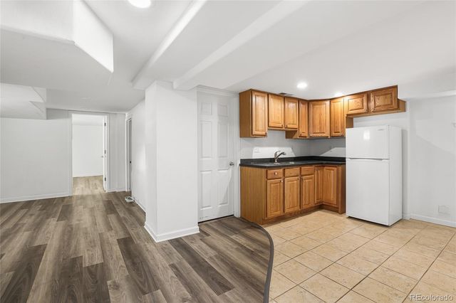 a kitchen with a refrigerator and a stove top oven