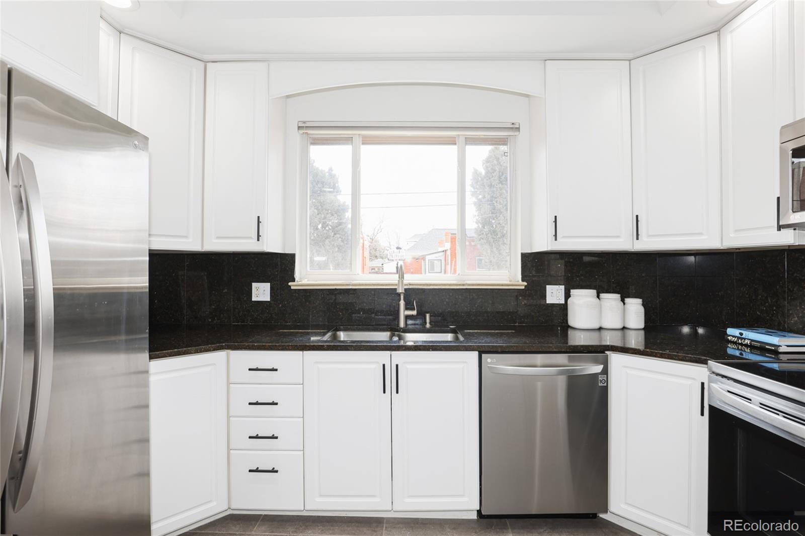 692 South Logan Street Denver, CO 80209 - Photo 8 of 40 a kitchen with granite countertop a sink cabinets and stainless steel appliances
