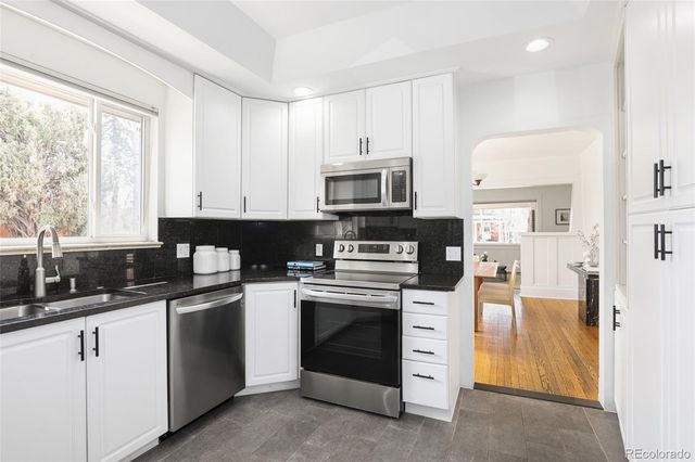 a kitchen with white cabinets and white appliances