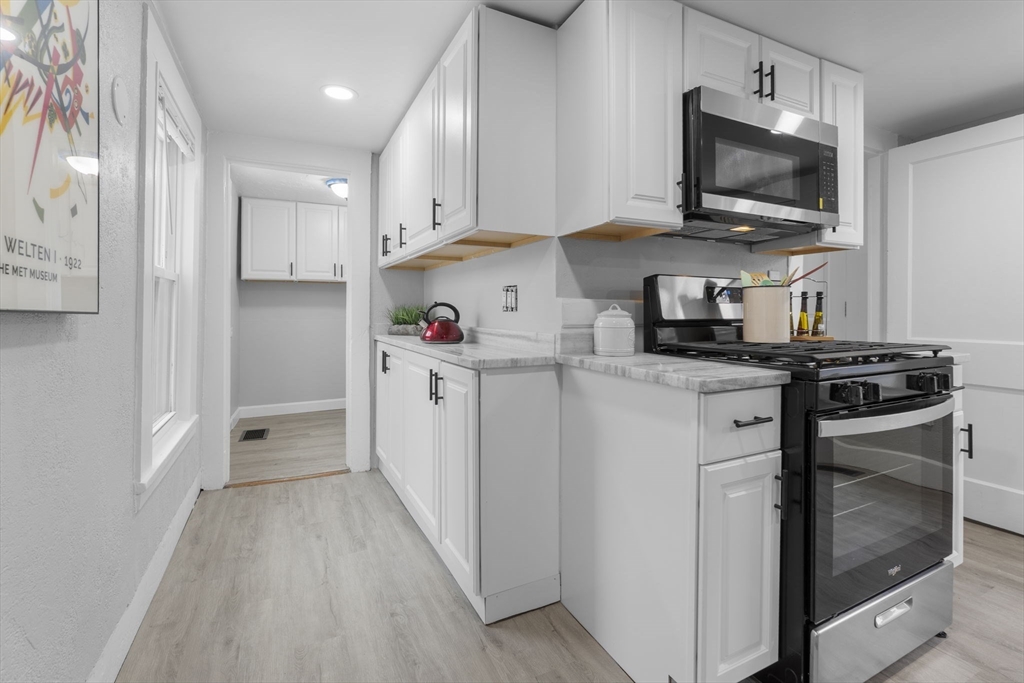 15 Reservoir Street Worcester, MA 01605 - Photo 13 of 35 a kitchen with white cabinets stainless steel appliances and sink