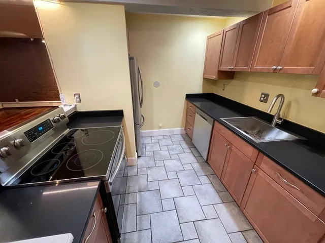 a kitchen with a sink a stove and cabinets