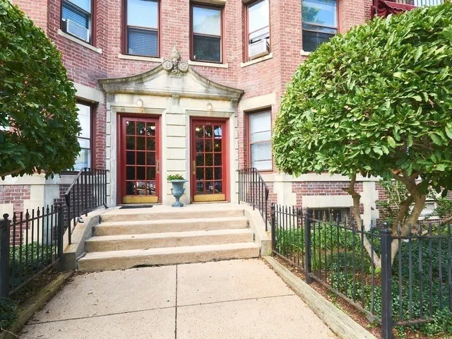 a view of a brick building with a tree in front