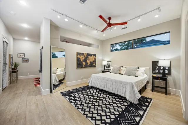 a bedroom with a large bed and a chandelier