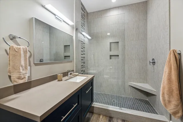 a bathroom with a sink a mirror and a shower