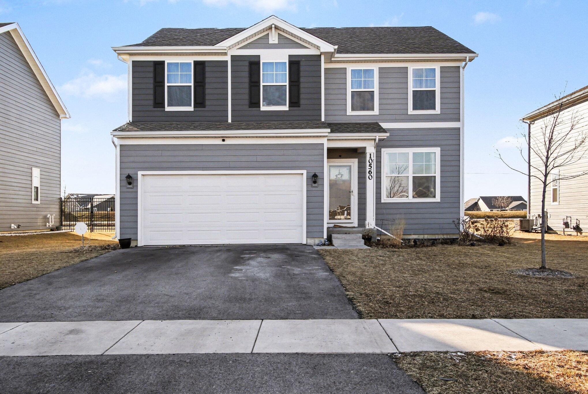 10560 Azalea Drive Crown Point, IN 46307 - Photo 2 of 26 a front view of a house with a yard and garage