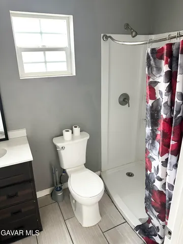 a bathroom with a toilet and a shower curtain