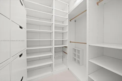 a view of walk in closet with empty racks