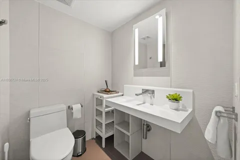 a bathroom with a sink toilet and mirror
