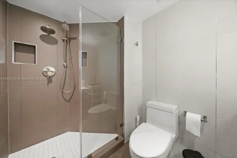 a white toilet sitting next to a bathroom sink and shower