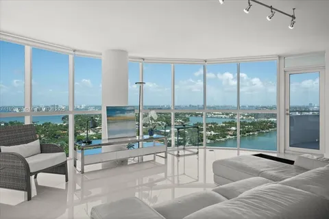 a living room with furniture and a floor to ceiling window