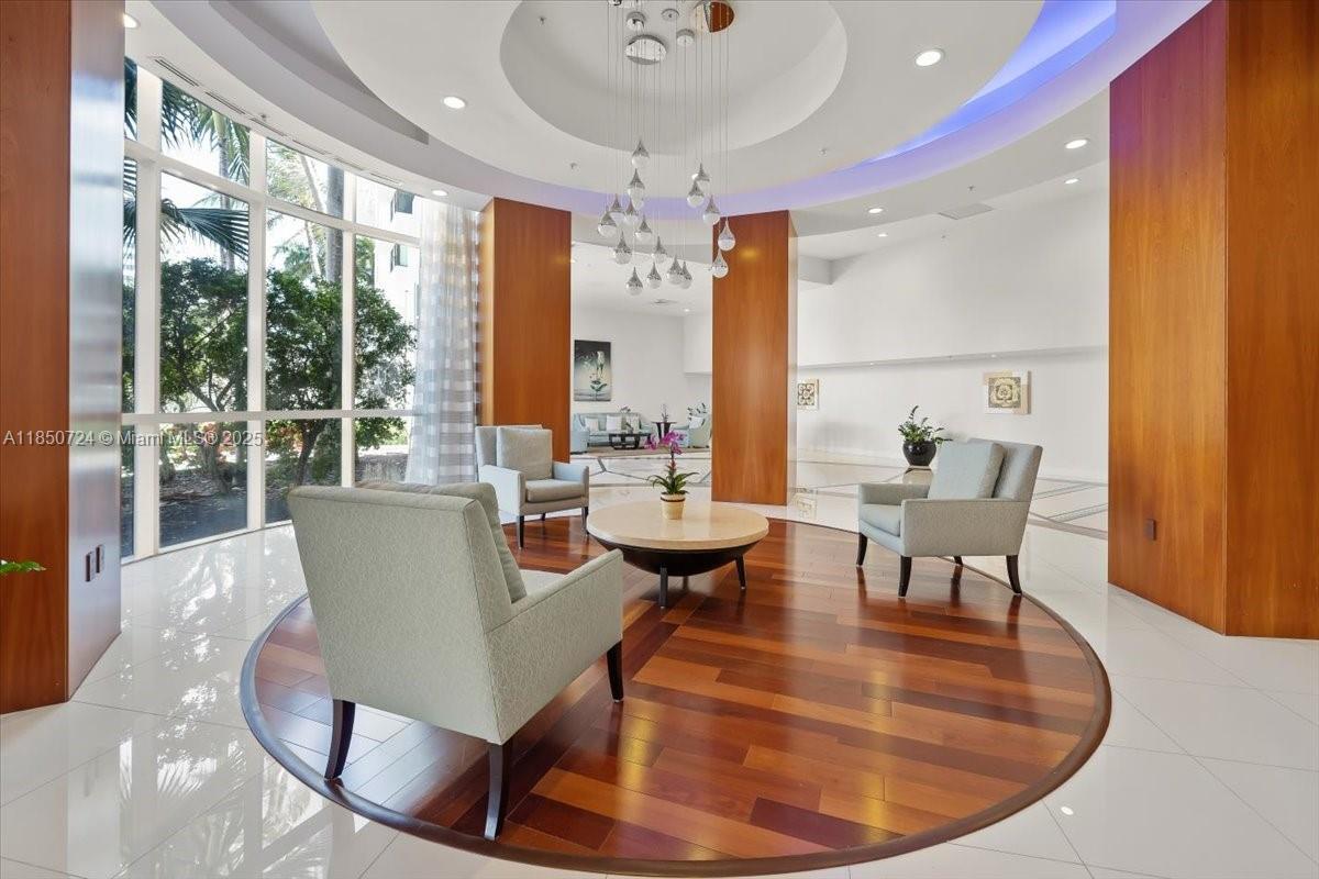6301 Collins Avenue, Unit 2705 Miami Beach, FL 33141 - Photo 22 of 41 a dining room with furniture a chandelier and wooden floor