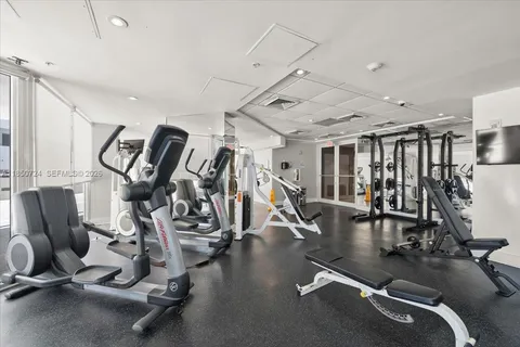 a gym area with gym equipment and a large window