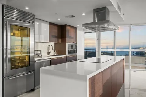 a kitchen with stainless steel appliances granite countertop a sink and a refrigerator