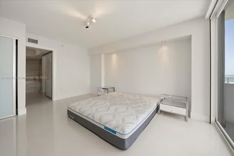 a bedroom with a bed and cabinet