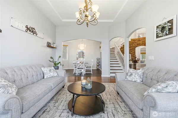 a living room with furniture chandelier and a table
