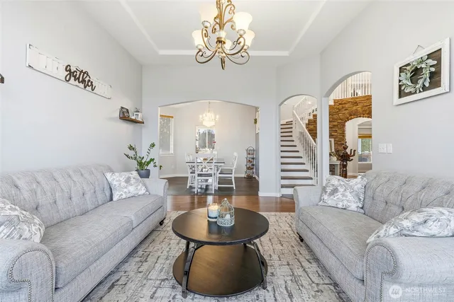 a living room with furniture chandelier and a table