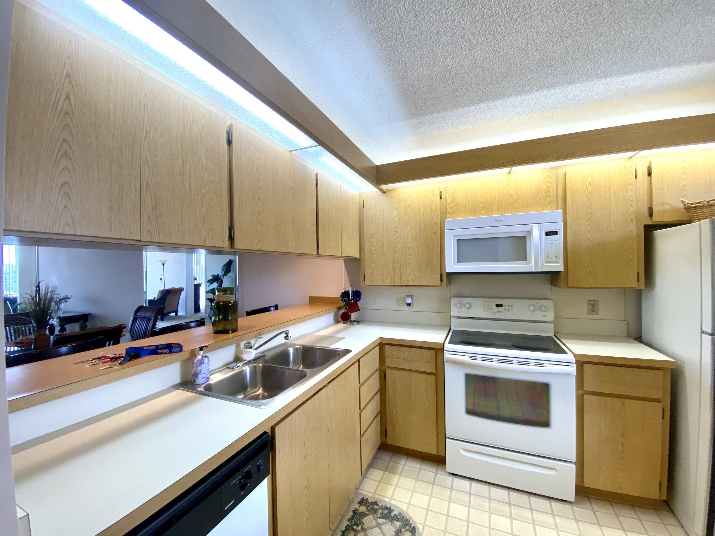 2301 Marina Isle Way, Unit 503 Jupiter, FL 33477 - Photo 23 of 45 a kitchen with a sink stove and cabinets
