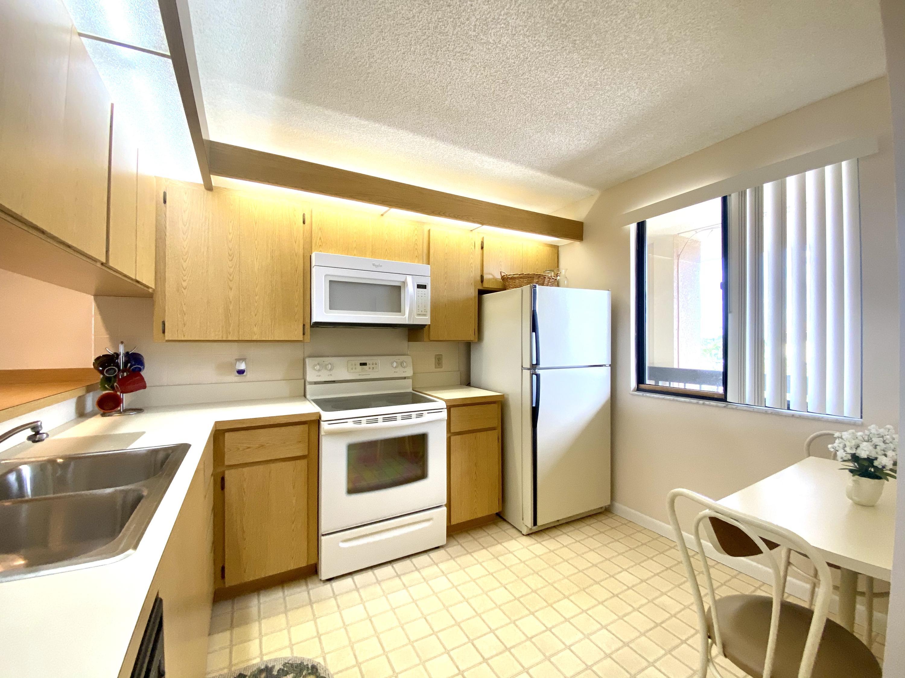 2301 Marina Isle Way, Unit 503 Jupiter, FL 33477 - Photo 34 of 45 a kitchen with a sink cabinets and appliances