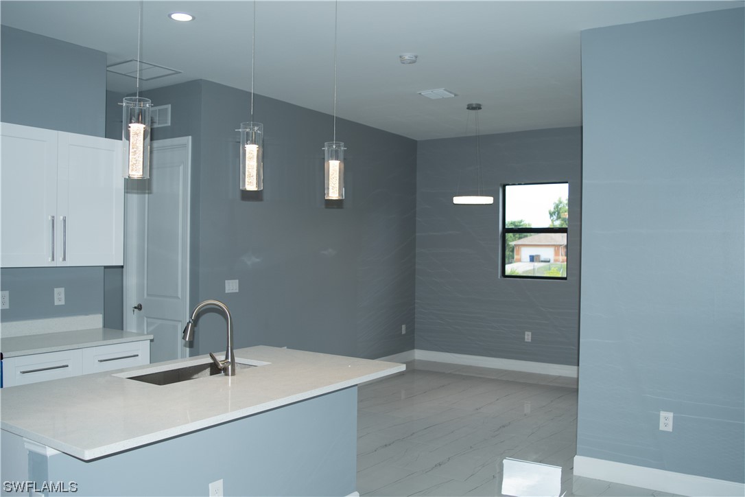 3718 41st Street Southwest Lehigh Acres, FL 33976 - Photo 11 of 28 a kitchen with a sink and a mirror