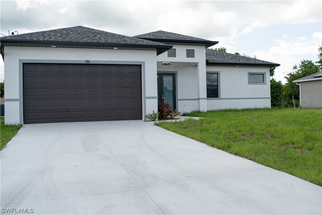 3718 41st Street Southwest Lehigh Acres, FL 33976 - Photo 4 of 28 a front view of a house with a yard and garage