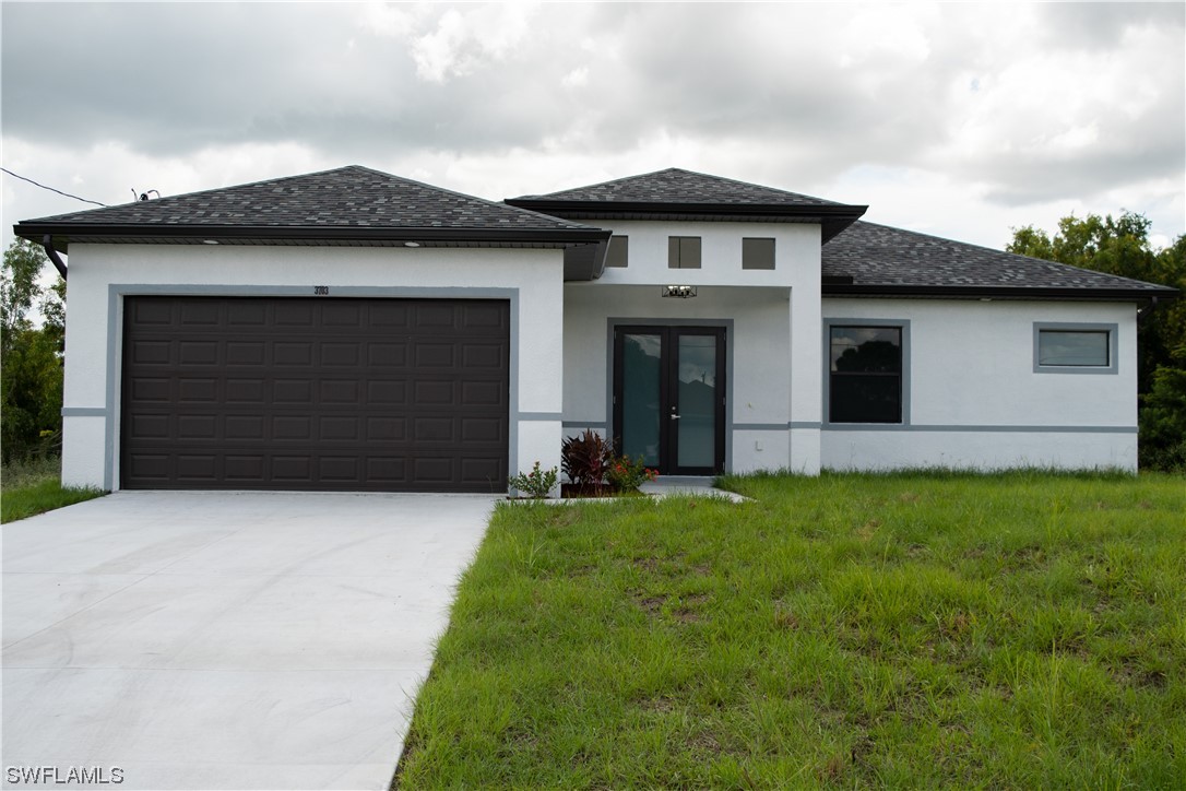 3718 41st Street Southwest Lehigh Acres, FL 33976 - Photo 5 of 28 a front view of a house with a yard and garage