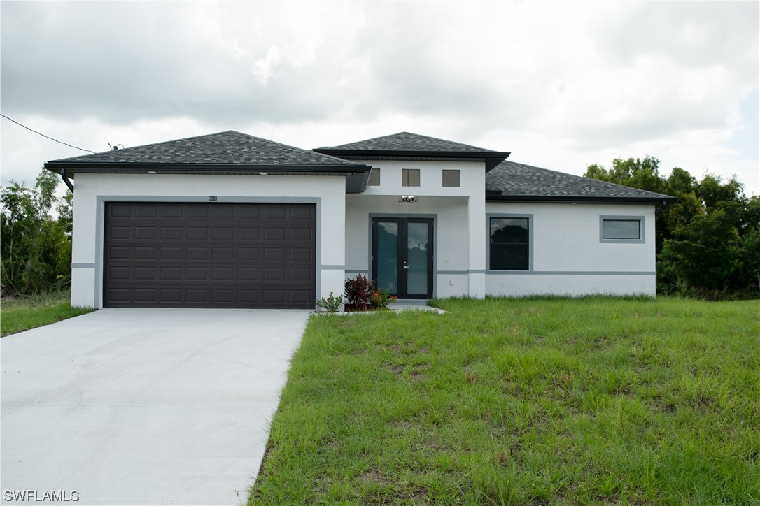 3718 41st Street Southwest Lehigh Acres, FL 33976 - Photo 6 of 28 a front view of a house with a yard and garage