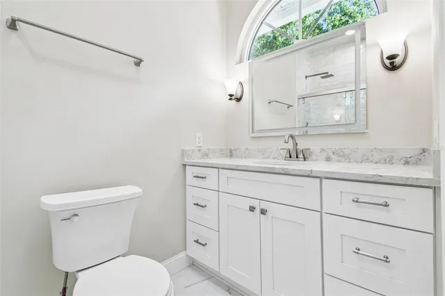 a bathroom with a granite countertop toilet a sink and a bathtub