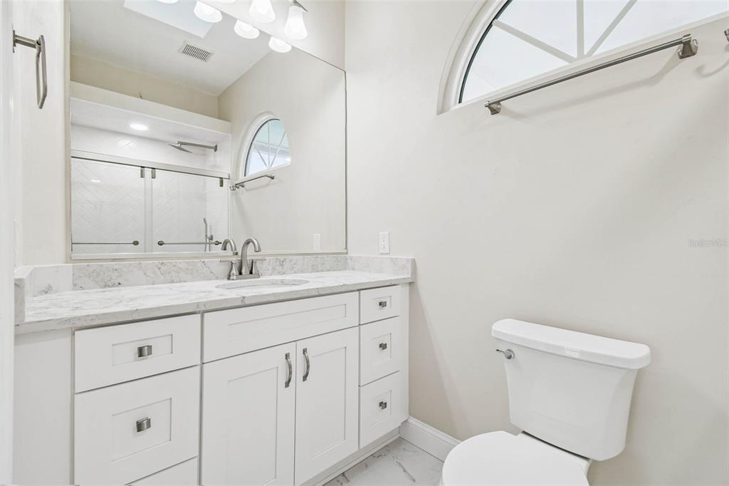 3505 Berger Road Lutz, FL 33548 - Photo 49 of 79 a bathroom with a granite countertop toilet sink and mirror