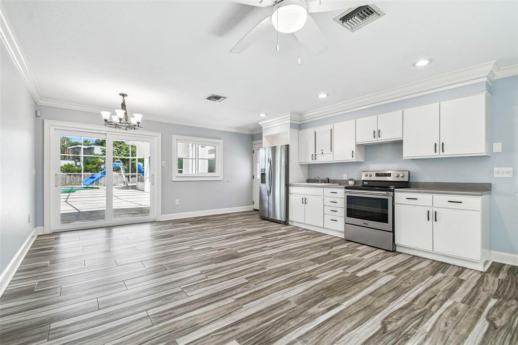 3505 Berger Road Lutz, FL 33548 - Photo 63 of 79 a kitchen with granite countertop a stove cabinets and wooden floor