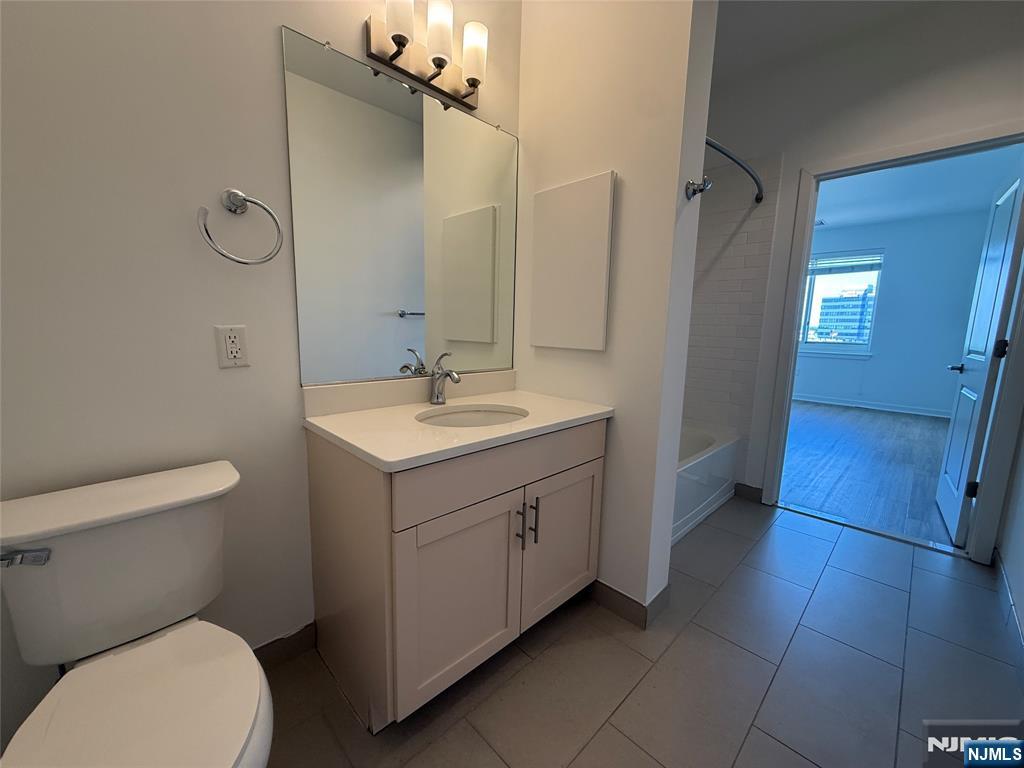 2050 North Central Road, Unit 710 Fort Lee, NJ 07024 - Photo 7 of 21 a bathroom with a sink mirror vanity and toilet