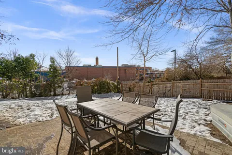 a view of a patio with a table and chairs and wooden fence