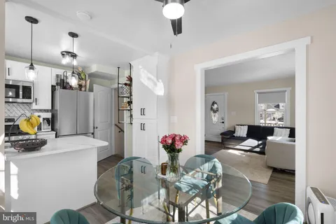 a living room with furniture kitchen view and a chandelier