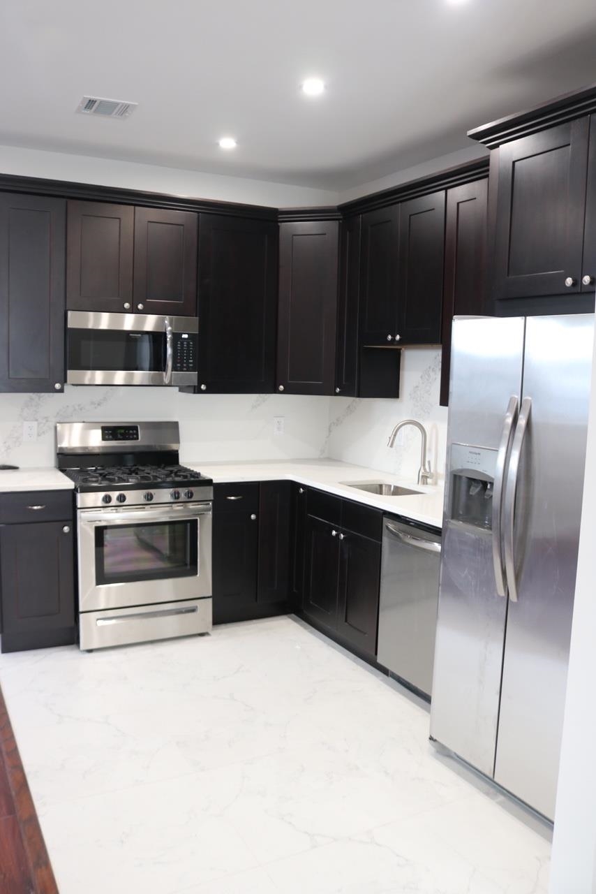 2110 Summit Avenue, Unit 2 Union City, NJ 07087 - Photo 2 of 11 a kitchen with stainless steel appliances kitchen island granite countertop a stove a refrigerator and a microwave