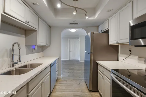 a kitchen with granite countertop a sink and refrigerator