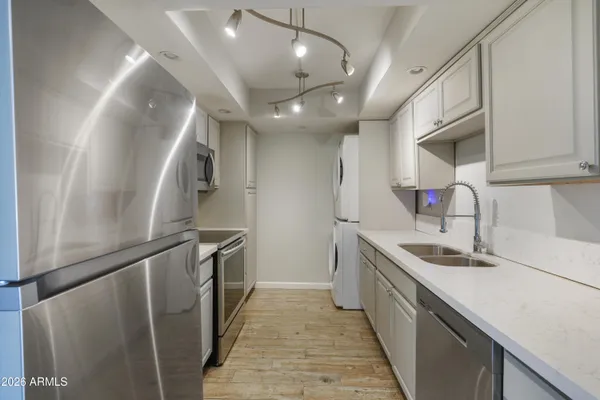 a kitchen with granite countertop a sink and refrigerator