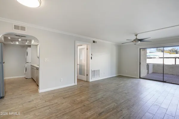 a view of a big room with wooden floor and windows