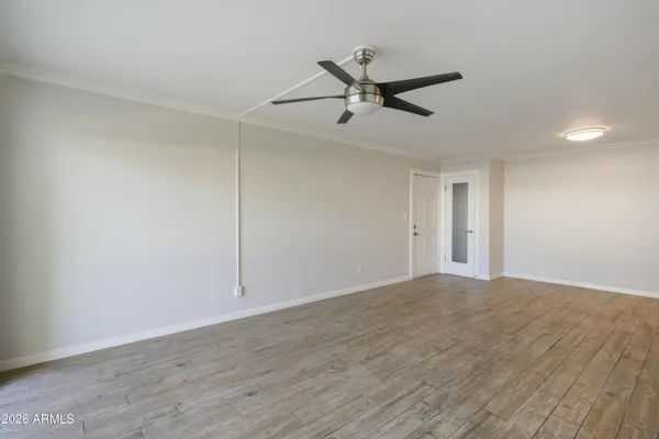a view of empty room with wooden floor