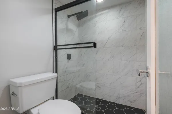 a white toilet sitting next to a shower