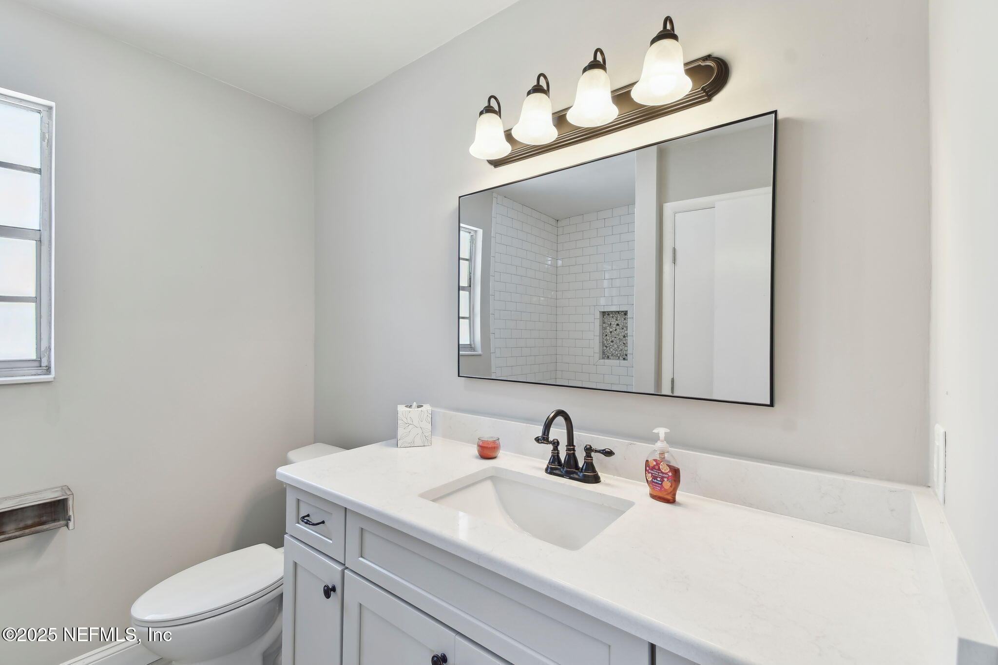 12277 Mandarin Road Jacksonville, FL 32223 - Photo 35 of 74 a bathroom with a toilet sink and mirror