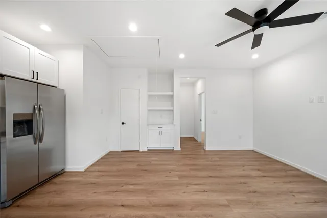 a view of empty room with wooden floor and window