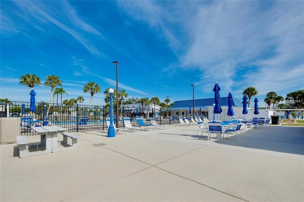 706 Roma Road Venice, FL 34285 - Photo 18 of 24 a view of a patio with dining table and chairs under an umbrella