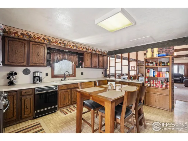 a kitchen with stainless steel appliances granite countertop a table chairs and a refrigerator