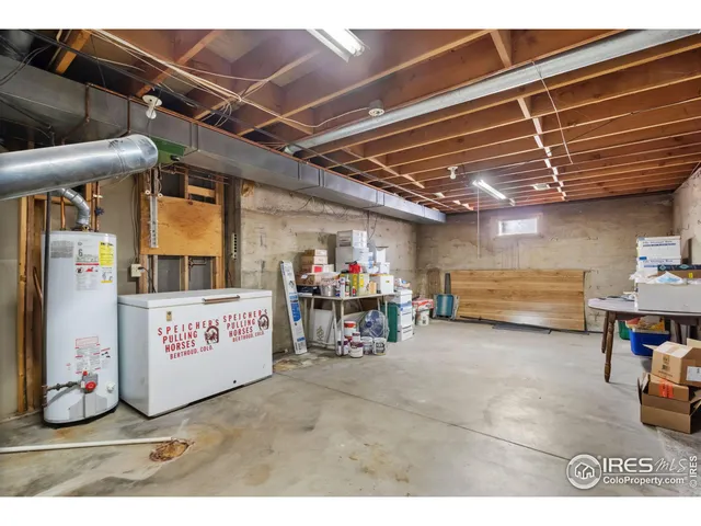 a living room with stainless steel appliances furniture a rug and a view of kitchen