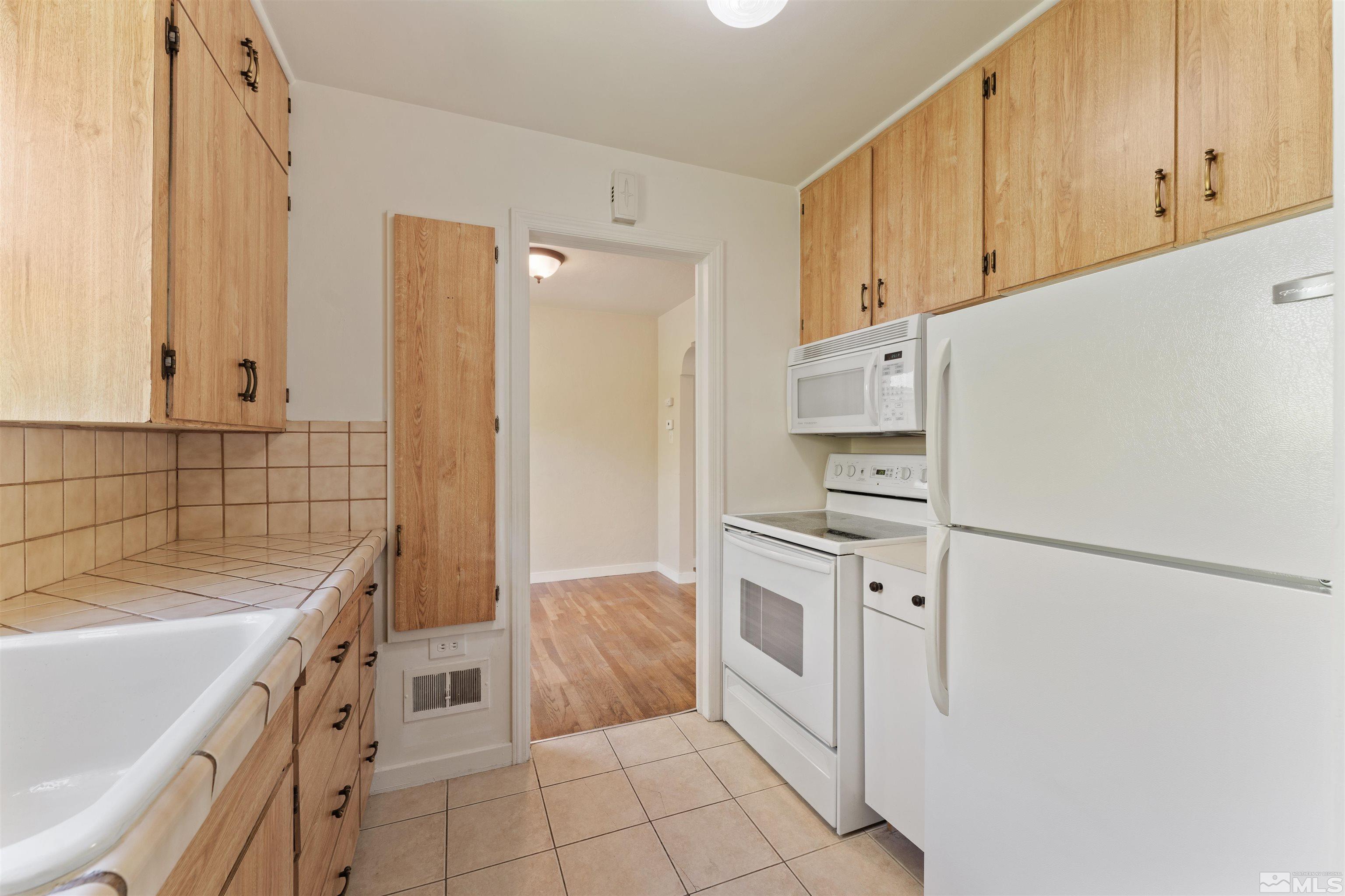 1624 Watt Street Reno, NV 89509 - Photo 9 of 40 a kitchen with white cabinets and white appliances
