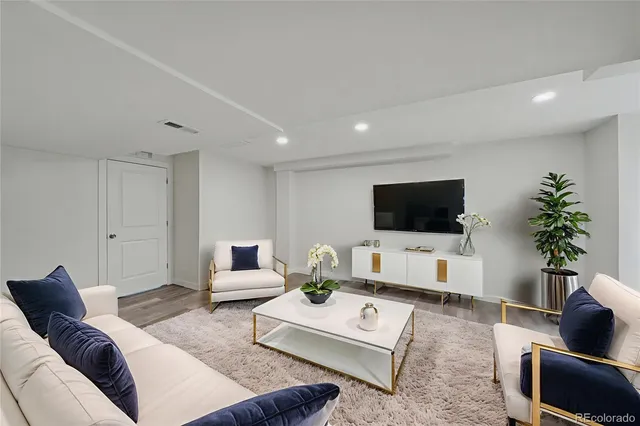 a living room with furniture a flat screen tv and a couch